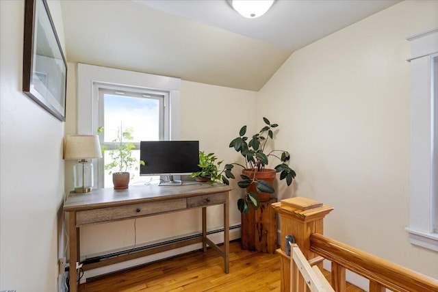 office featuring lofted ceiling, a baseboard heating unit, and light wood-type flooring