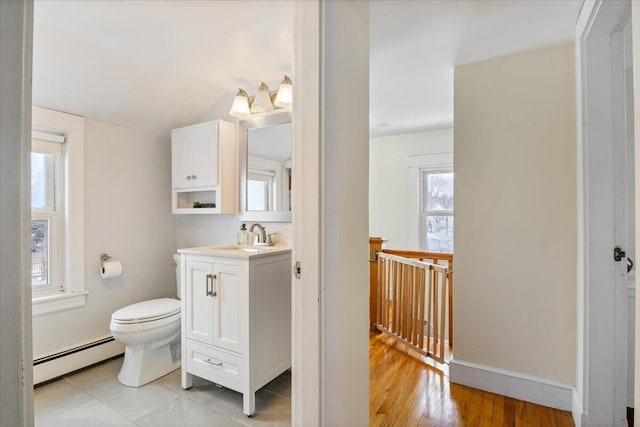 bathroom featuring lofted ceiling, hardwood / wood-style flooring, toilet, vanity, and baseboard heating