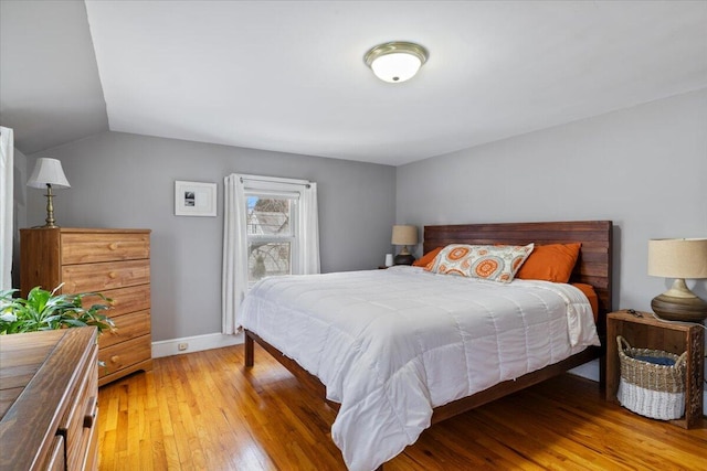 bedroom with vaulted ceiling and wood-type flooring