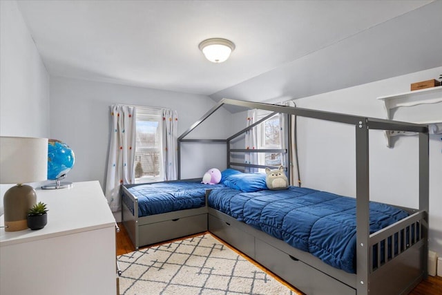 bedroom featuring lofted ceiling and light wood-type flooring