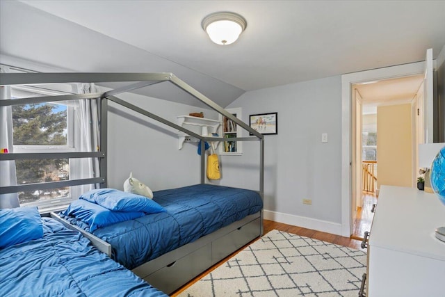 bedroom featuring lofted ceiling and hardwood / wood-style flooring