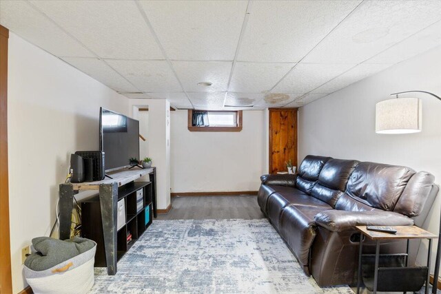 living room featuring a paneled ceiling and hardwood / wood-style floors