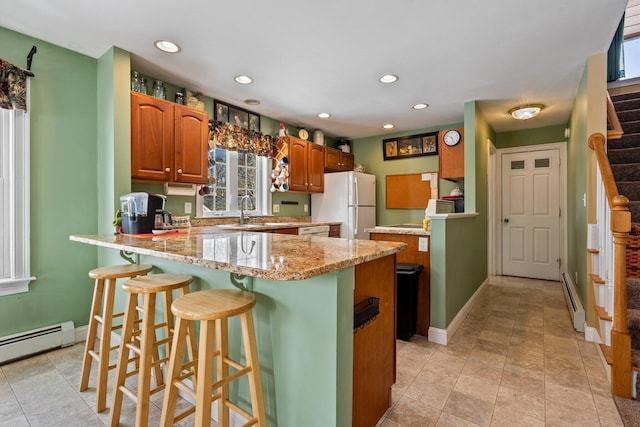 10 Seaside Ave, Saco, ME 04072 - kitchen with white appliances, a peninsula, a baseboard radiator, a kitchen bar, and recessed lighting
