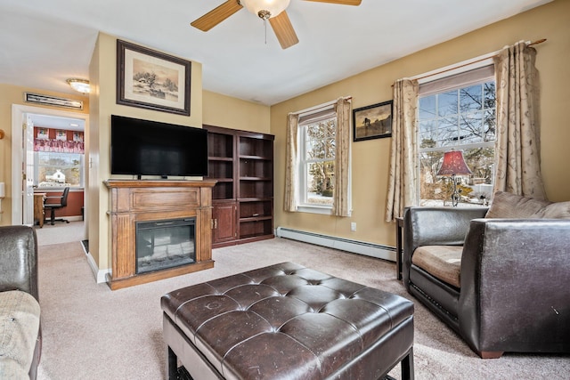 10 Seaside Ave, Saco, ME 04072 - carpeted living room featuring a baseboard radiator, a ceiling fan, a glass covered fireplace, and baseboards