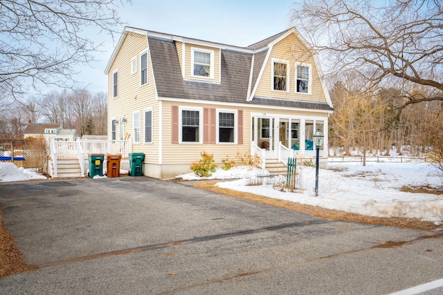 view of front of house with a gambrel roof and roof with shingles