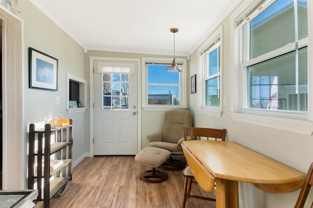living area featuring hardwood / wood-style flooring, a healthy amount of sunlight, and crown molding
