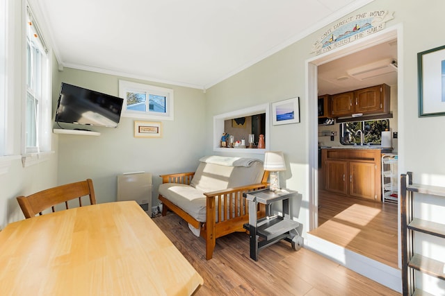 bedroom featuring ornamental molding, beverage cooler, light hardwood / wood-style floors, and sink