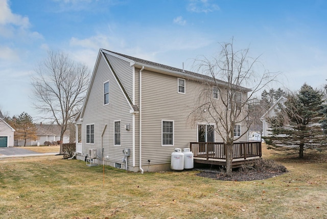 rear view of house featuring a yard and a deck