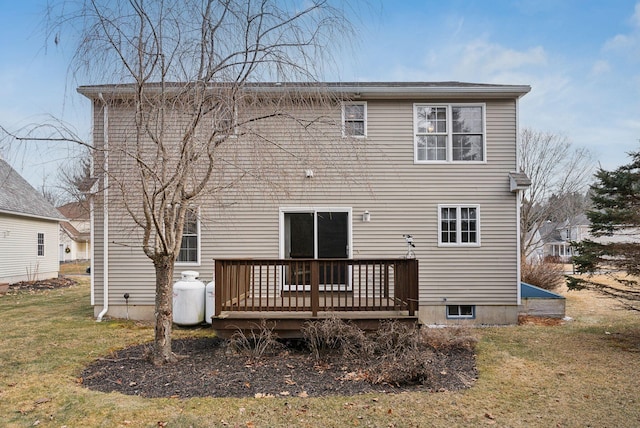 rear view of house with a deck and a yard