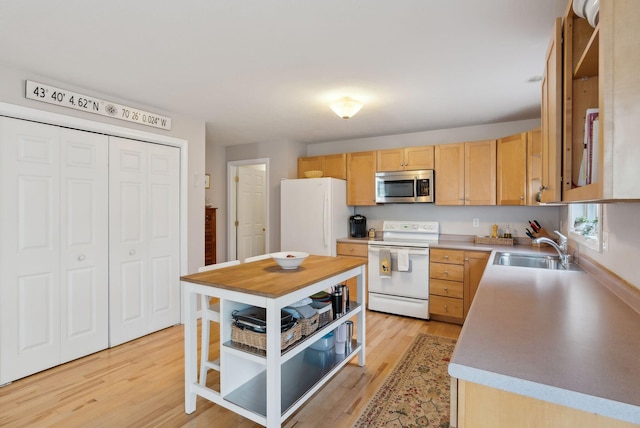 kitchen featuring light wood-type flooring, white appliances, sink, and light brown cabinetry