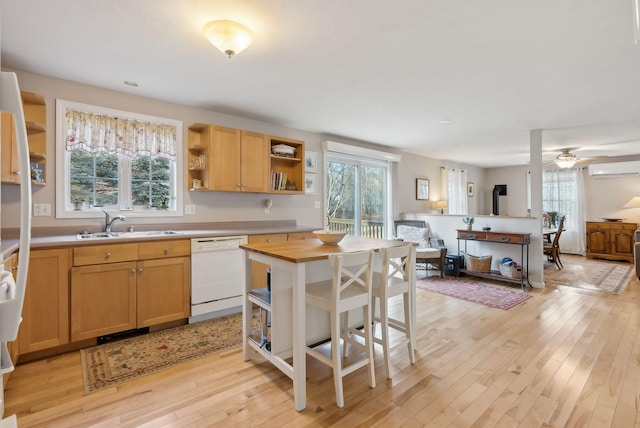 kitchen with sink, white dishwasher, wooden counters, and plenty of natural light