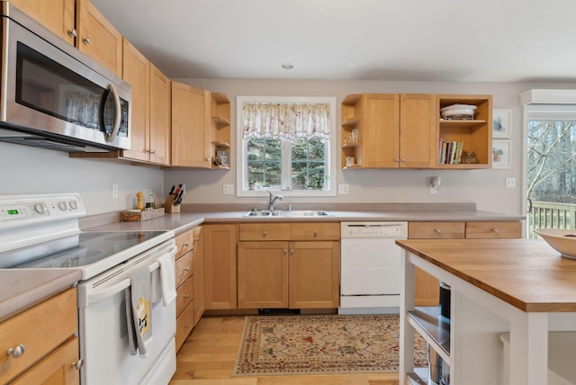 kitchen featuring sink, a healthy amount of sunlight, white appliances, and wooden counters