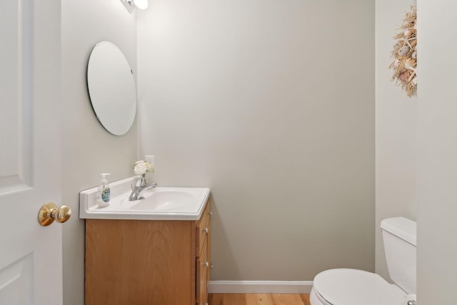 bathroom with vanity, hardwood / wood-style flooring, and toilet