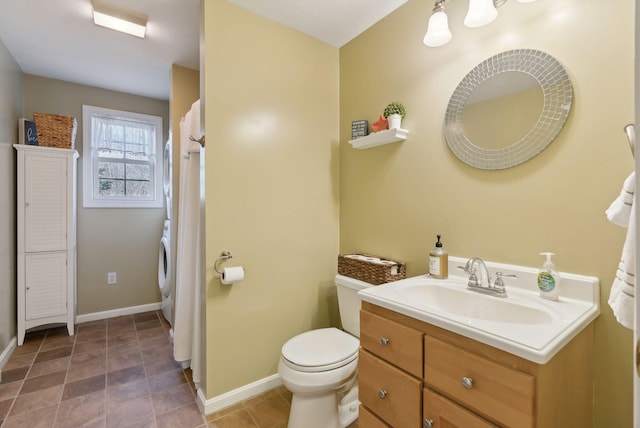 bathroom featuring vanity, washer / clothes dryer, and toilet