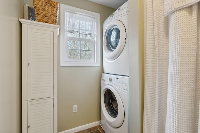 laundry area featuring tile patterned flooring and stacked washer / drying machine