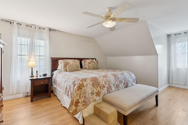 bedroom with ceiling fan, light hardwood / wood-style floors, and vaulted ceiling