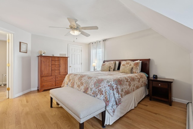 bedroom featuring ceiling fan, light hardwood / wood-style floors, and baseboard heating