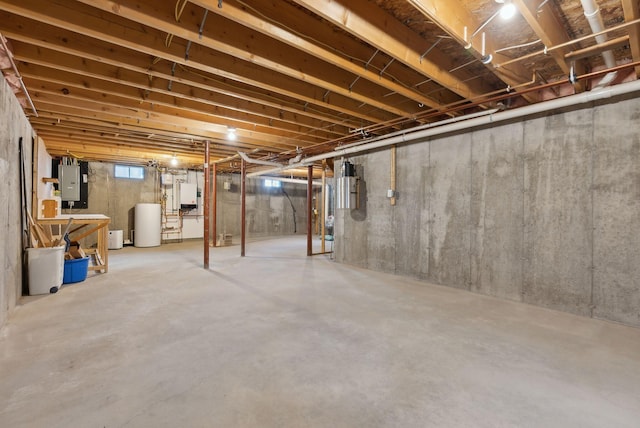 basement featuring electric panel and water heater