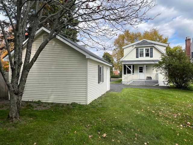 rear view of property with a lawn and a porch