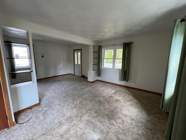 unfurnished living room with light colored carpet