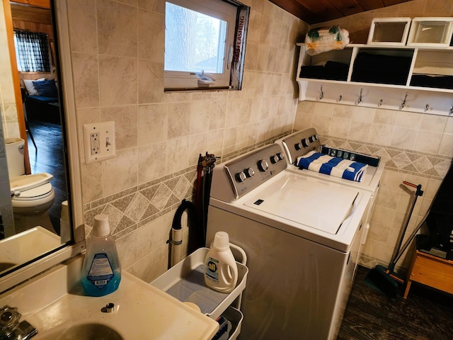 laundry area with washer and clothes dryer and tile walls