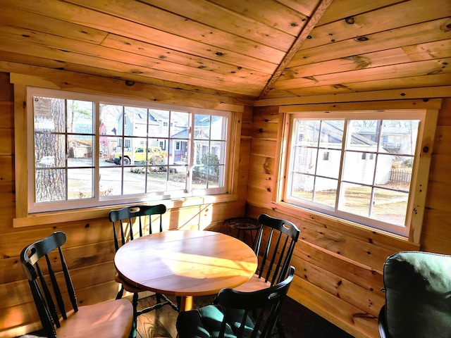 dining area featuring wood walls, wooden ceiling, and lofted ceiling