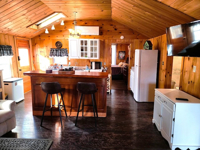 kitchen with a center island, white fridge, and white cabinets