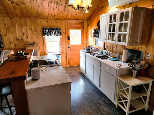 kitchen with wood ceiling, wooden walls, sink, white cabinets, and lofted ceiling