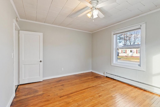 spare room featuring ceiling fan, light wood-type flooring, ornamental molding, and a baseboard radiator