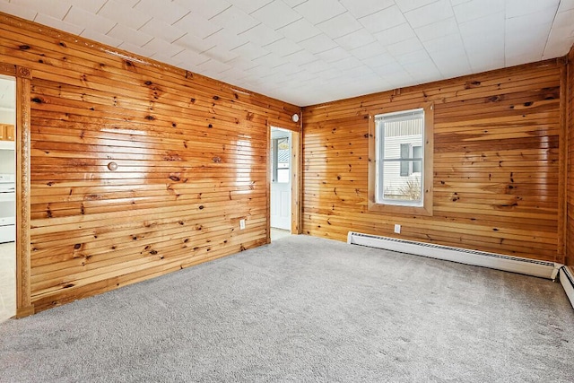 carpeted empty room with baseboard heating and wooden walls