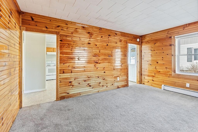 carpeted spare room featuring wooden walls and a baseboard heating unit