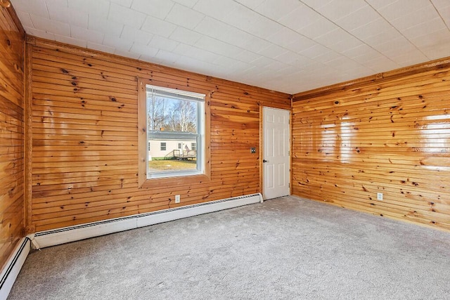 carpeted empty room with wooden walls and a baseboard radiator