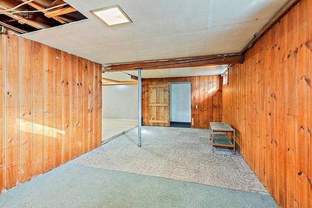 basement with carpet flooring and wood walls