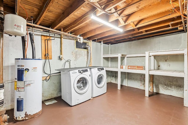 clothes washing area featuring water heater and washer and dryer