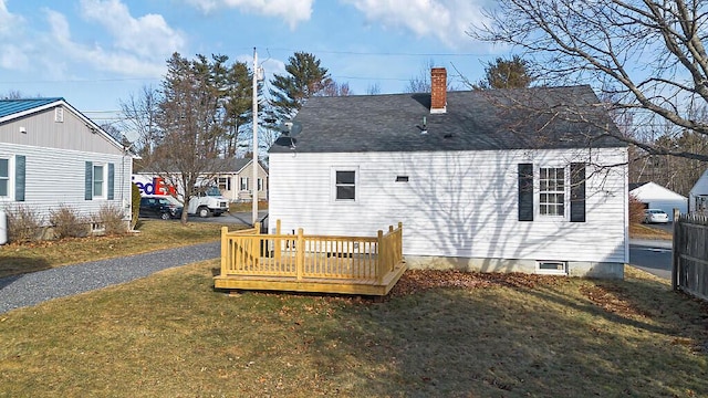 back of property featuring a lawn and a wooden deck