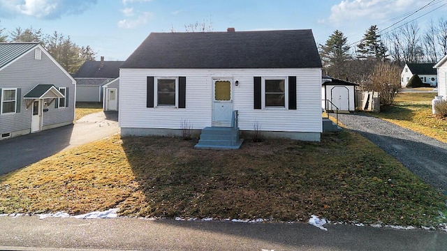 bungalow-style home with a storage unit