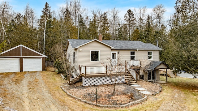 view of front of property featuring a deck, an outdoor structure, and a garage