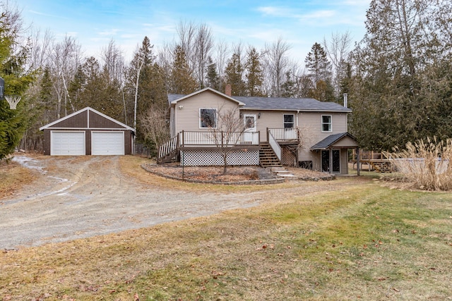 view of property with a front yard, a wooden deck, an outdoor structure, and a garage