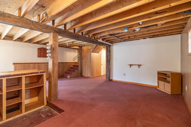 basement with carpet floors and wood walls