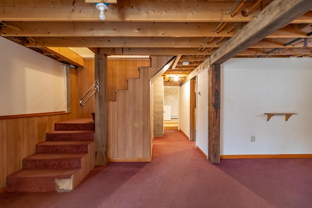 basement featuring wooden walls and carpet flooring