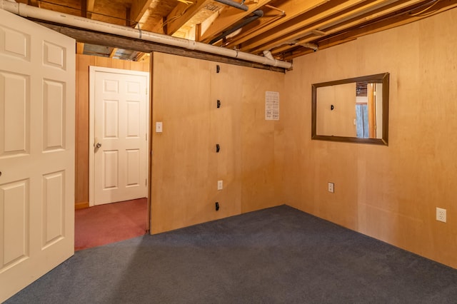 basement with wood walls and dark carpet