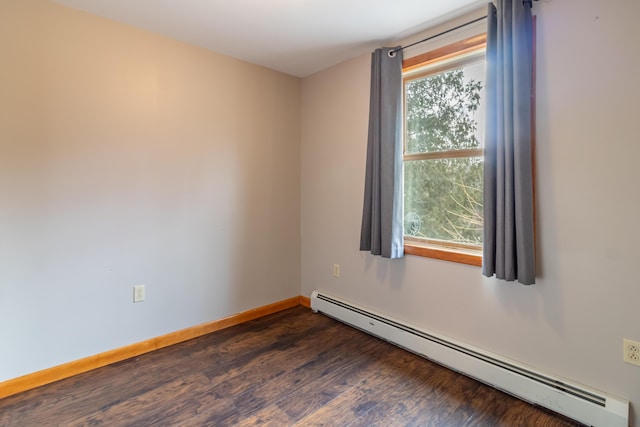 unfurnished room featuring baseboard heating and dark hardwood / wood-style floors