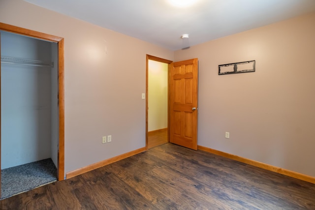 unfurnished bedroom featuring dark wood-type flooring and a closet