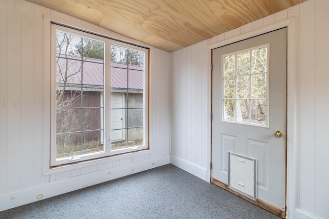 doorway to outside with vaulted ceiling, wood ceiling, and wood walls