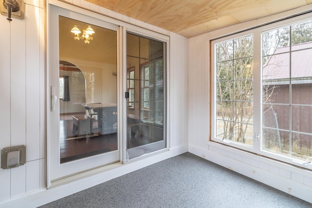 unfurnished sunroom featuring wood ceiling and a notable chandelier