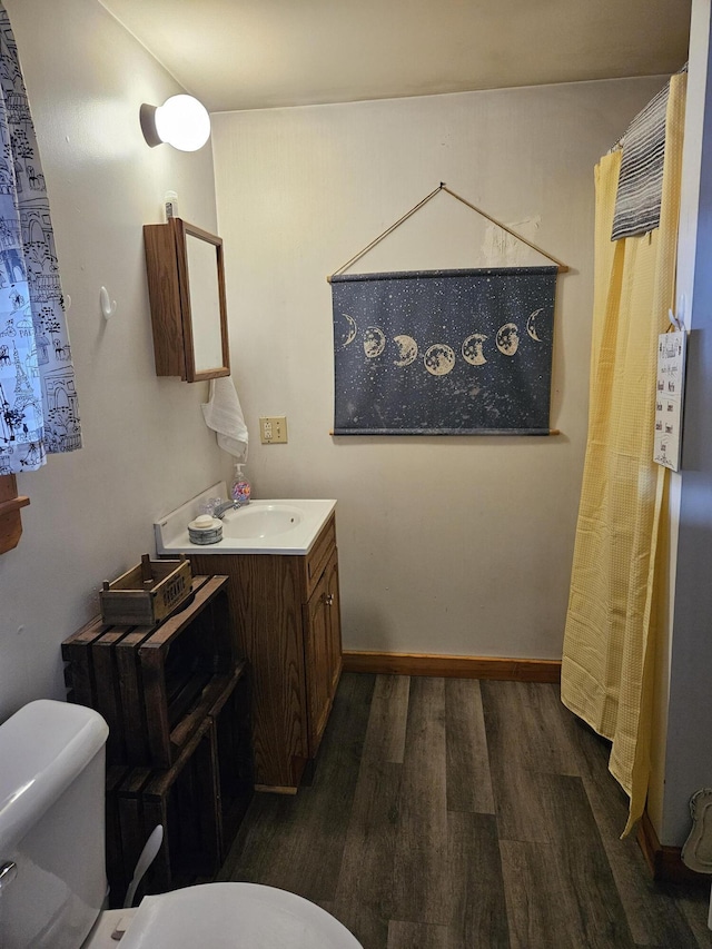 bathroom featuring wood-type flooring, vanity, and toilet