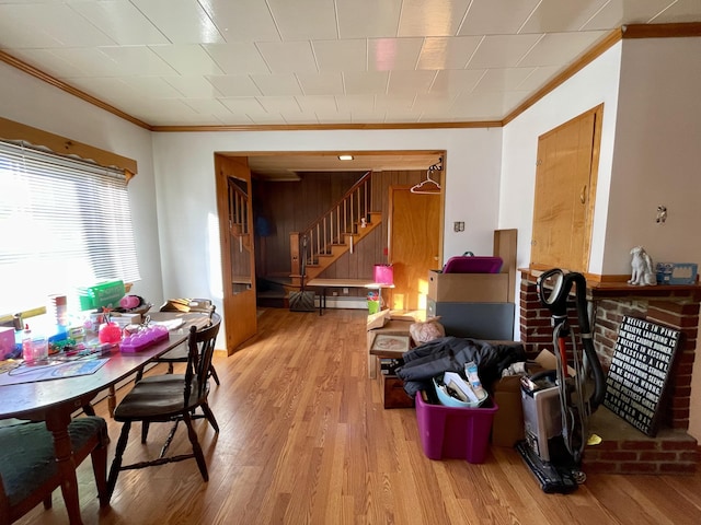 dining area with crown molding, a baseboard radiator, and light wood-type flooring