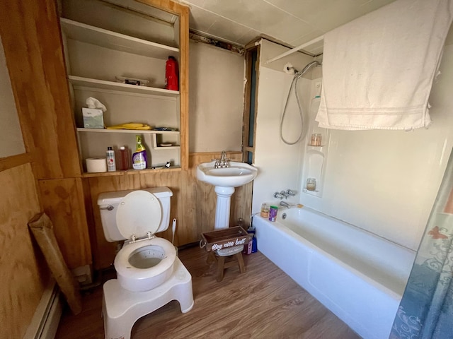 bathroom with shower / bathtub combination with curtain, hardwood / wood-style floors, toilet, and a baseboard heating unit