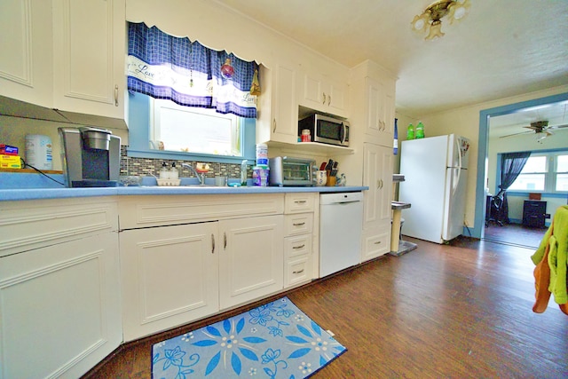 kitchen featuring sink, white appliances, white cabinetry, dark hardwood / wood-style flooring, and decorative backsplash