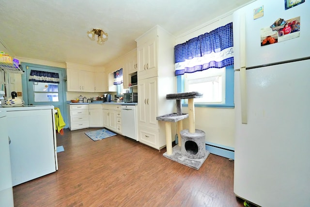 kitchen with white appliances, dark wood-type flooring, baseboard heating, white cabinets, and washer / dryer